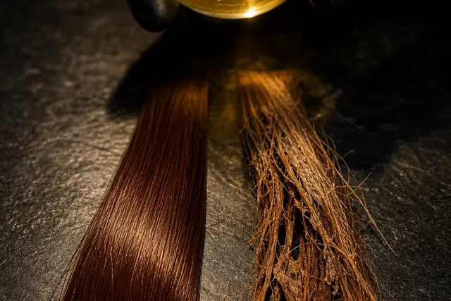 Fios de cabelo acobreado avermelhado sob luz dourada em fundo escuro